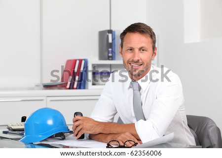 Site manager in the office with blue helmet