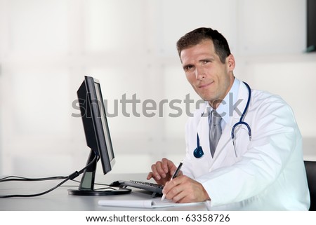 Closeup of doctor at his desk in front of computer