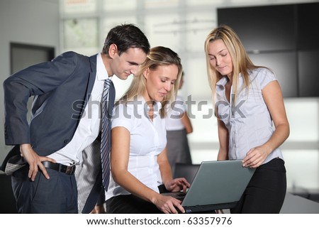 Co-workers with laptop computer in the office