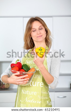 Woman in kitchen ready to prepare meal with vegetables