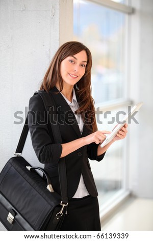 Businesswoman standing in hall with electronic pad