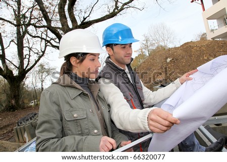 Architect and engineer looking at plan on construction site