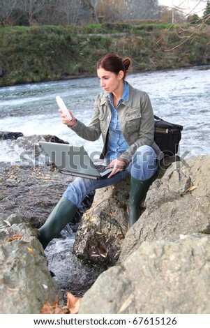 Woman scientist testing quality of water in river