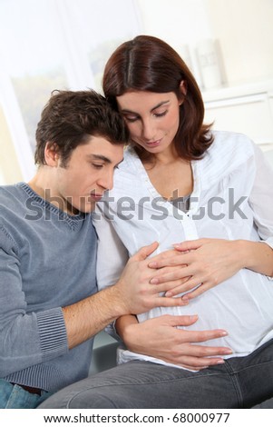 Future father listening to heartbeat of baby