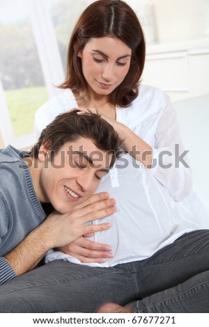 Future father listening to heartbeat of baby