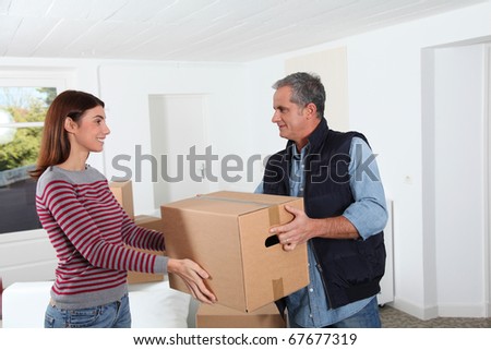 Young woman with removal man holding boxes