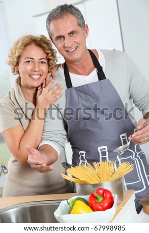 Happy couple preparing italian dinner at home