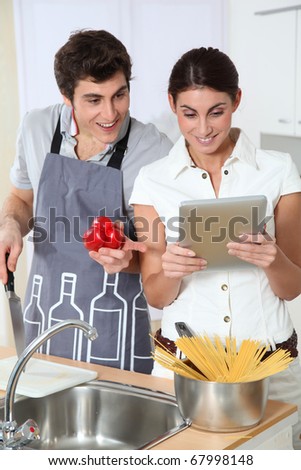 Couple looking at italian recipe on electronic tab