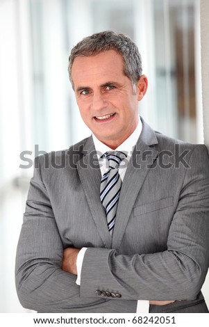 Businessman in grey suit standing in offices hall