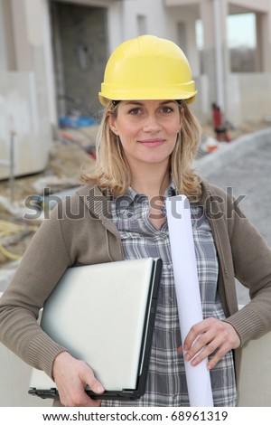 Woman engineer with security helmet standing on construction site