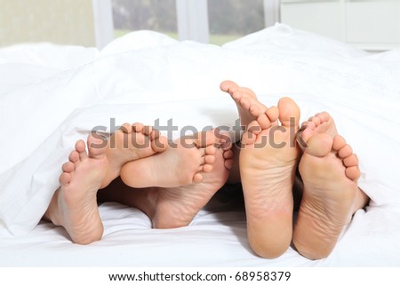 Closeup of family feet in bed