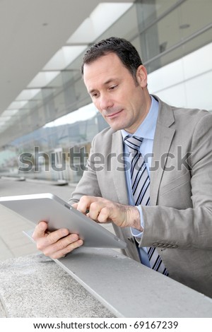 Businessman using electronic tab outside congress center