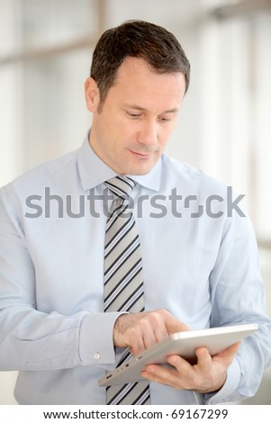 Businessman standing in hall with electronic tab