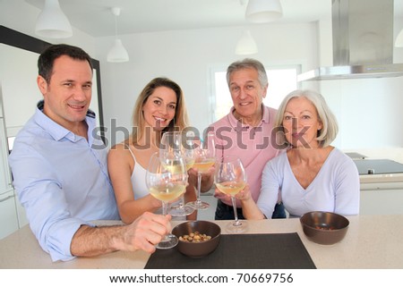 Family in home kitchen drinking wine