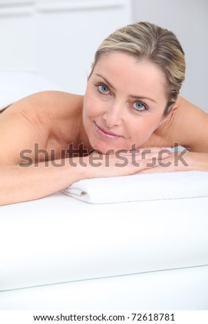 Beautiful adult blond woman on massage bed