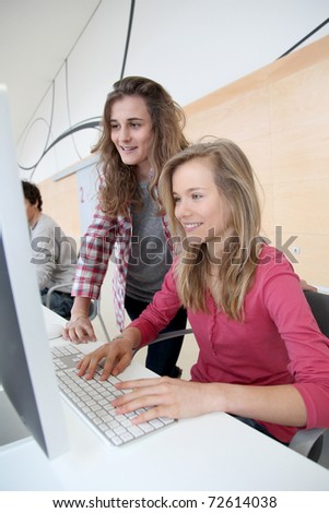 Teenage girls in front of desktop computer at school