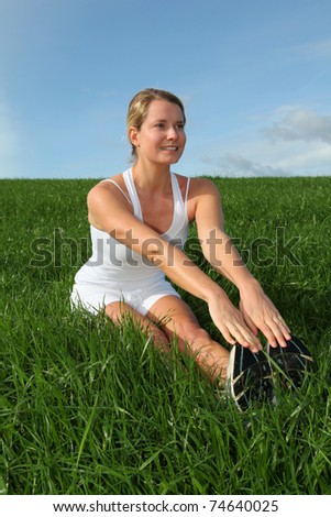 Beautiful woman doing fitness exercises in nature