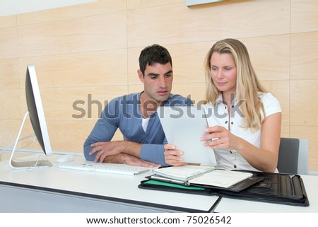 Office workers in office with electronic tablet