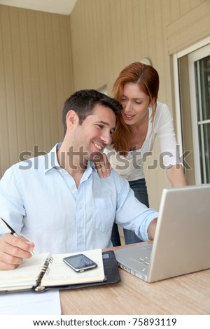 Self-employed man working at home with wife
