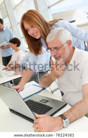 Senior man with trainer in front of laptop computer