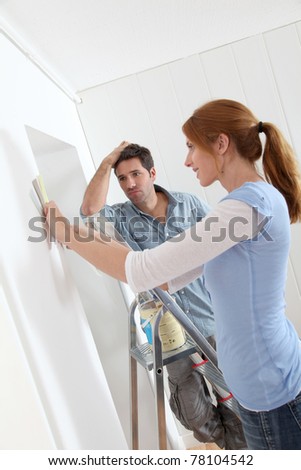 Couple choosing wallpaper color for new house