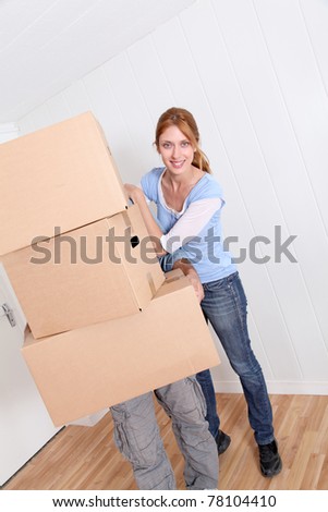 Couple carrying boxes to move in new house