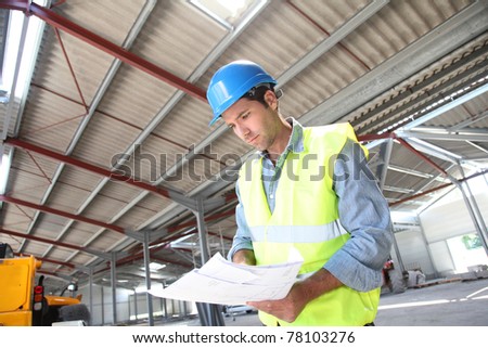 Engineer checking plan in building under construction