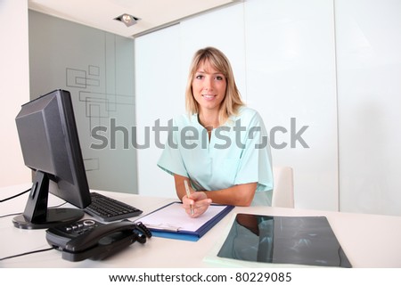 Nurse working on desktop computer in office
