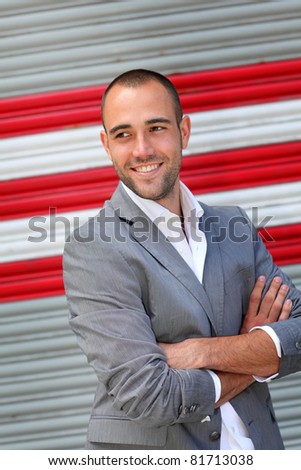Attractive man with arms crossed on striped background