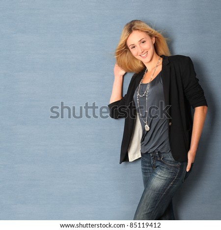 Beautiful charming woman leaning on blue wall