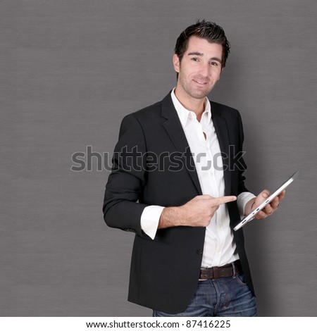 Smiling man standing on dark background
