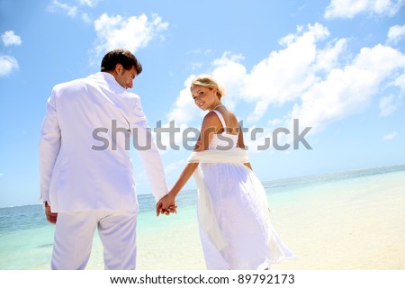 Just-married couple standing by blue lagoon