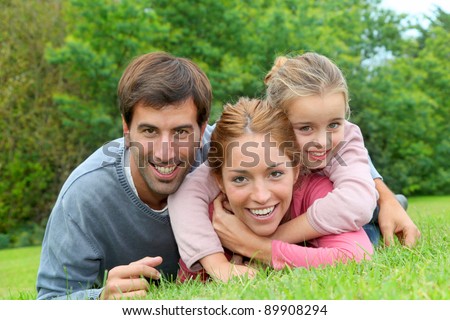 Portrait of cheerful family laying on grass