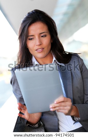 Businesswoman using electronic tablet outside the office