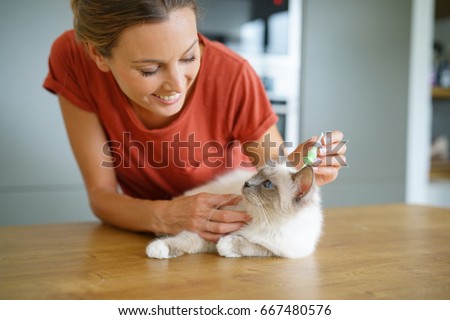 Woman injecting cat product to prevent from fleas