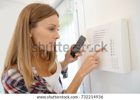 Woman programming home security alarm system