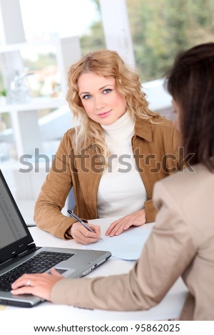 Beautiful woman signing contract in insurance company