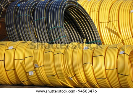 Stock black and yellow coiled plastic pipes