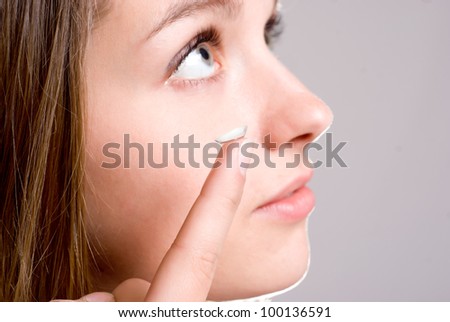 A girl holds a contact lens, focus on the lens