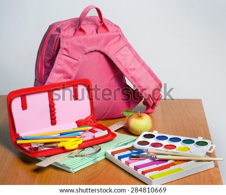 Portfolio and school supplies on the table