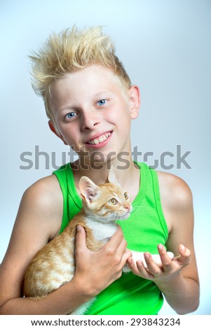 Boy teenager hugging ginger kitten
