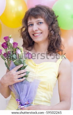 Funny girl with flowers in their hands against the backdrop of balloons