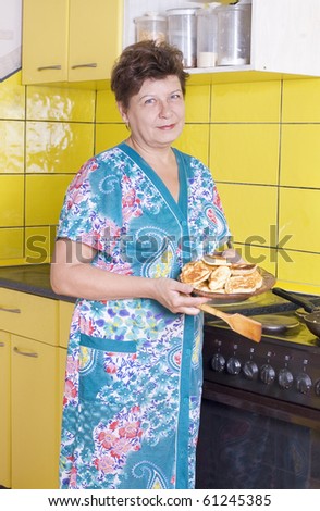 The woman has fried fritters, costs near a cooker