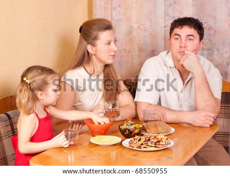 Family on kitchen behind a table, conversation