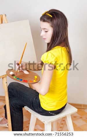 Girl with a palette of paints for the easel
