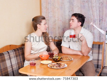 A husband and wife at the table drinking tea in the kitchen