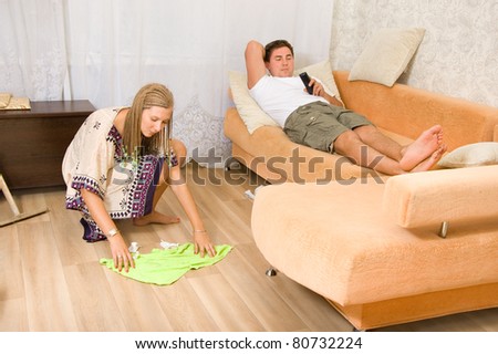 The woman washes the floors and my husband lying on the sofa