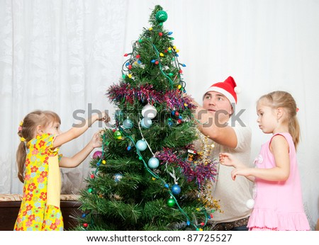 The family decorate the Christmas tree