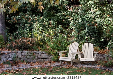 Lawn chairs in the backyard surrounded by fallen maple leaves