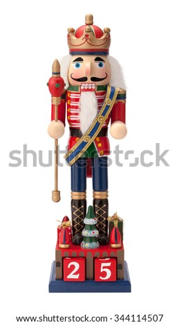 Antique Christmas Nutcracker Monarch holding a scepter. He wears a crown and sash with his uniform. The point of view is straight on, and is isolated on a white background.